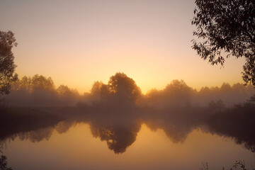 Autumn foggy landscape over the lake