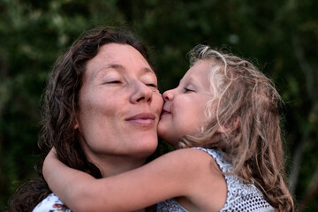 maman et fille partageant des moments authentiques et des bisous en plein air