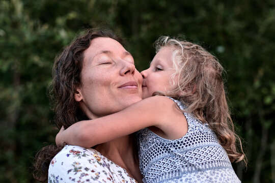maman et fille partageant des moments authentiques et des bisous en plein air