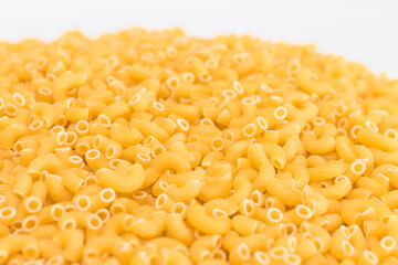 A Heap of Uncooked Chifferi Rigati Pasta on White Background. Fat and Unhealthy Food. Classic Dry Macaroni Texture. Italian Culture and Cuisine. Raw Pasta
