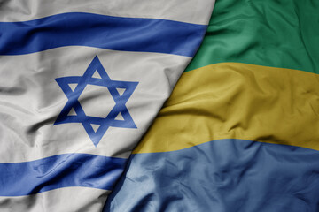 big waving national colorful flag of israel and national flag of gabon .