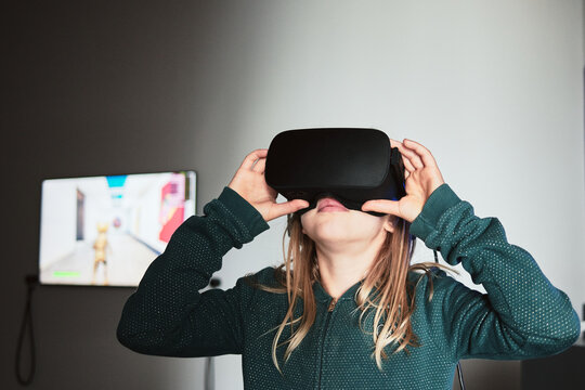 Exploration immersive, fille de 10 ans essayant des lunettes de r&eacute;alit&eacute; virtuelle