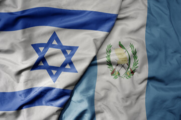 big waving national colorful flag of israel and national flag of guatemala .