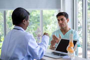 Female doctor and male patient Discuss and give advice about wrist and arm pain among patients in the hospital.