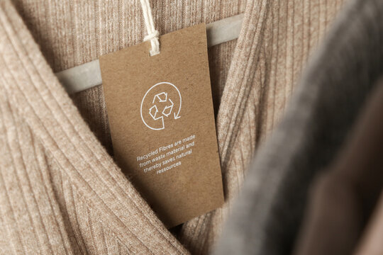 Close up of clothing tag with recycle icon. Recycling products concept. Zero waste, suistainale production, environment care and reuse concept.