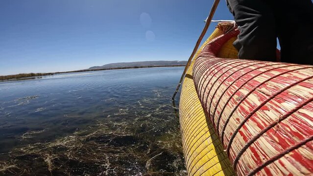 Local rowing traditional totora reed boat on Titicaca lake near Puno