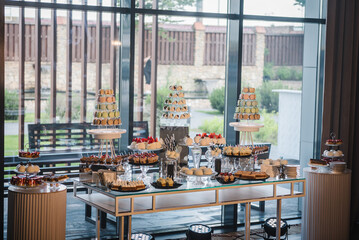 Candy bar on wedding feast closeup. Macaroons. Delicious reception luxury ceremony. Table with sweets, candies, and dessert. Tasty colorful french macaroons on a plate. Culinary and cooking concepts.