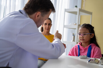 Male doctor and girl young patient Talk and give advice about your illness at the hospital.