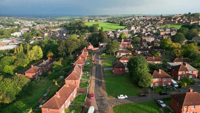 Vibrant urban life in the UK: Red brick council housing in Yorkshire, aerial drone, sunny morning, people.