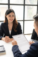 Young Asian woman is interviewing for a job in the office. Focus on tips for writing a resume...