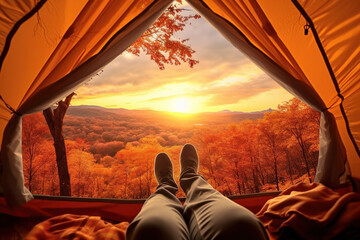 Traveler holding relaxing inside a orange tent and enjoy the view of sunset on autumn forest in national park