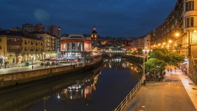 Dusk to night timelapse view of Bilbao cityscape including the historic La Ribera food market in Bilbao, Basque Country, Spain. 