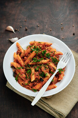 Traditional Italian cuisine: tasty pasta with bolognese sauce. Yummy macaroni (penne rigate) on rough wooden table