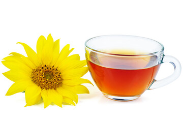 Black tea in the glass cup and sunflower near isolated on a white background. Copy space.
