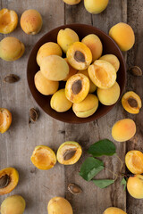Apricots on a wooden background. Summer orange fruits in a plate. Fruits in section.
