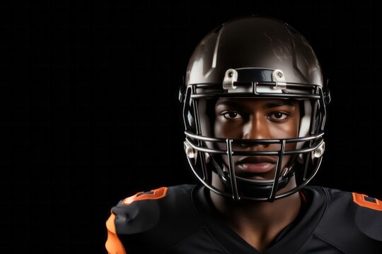 African american football player with ball wearing helmet and protective shields isolated over black background, close up - Powered by Adobe