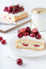 Decor for a pie made of fresh cherries and cream. Cake with cherries and vanilla cream. Summer fruits on a white background.