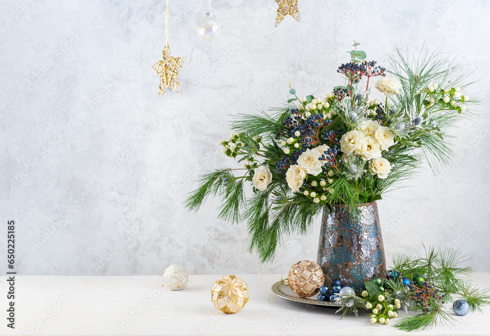 Wall mural Christmas decorations, candles and flower bouquet. Winter arrangement with roses, fir branches, winter berries. Christmas flower still life.