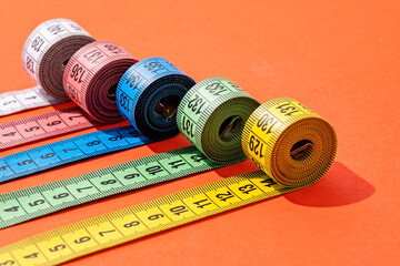 colorful measuring tapes top view on bright red background