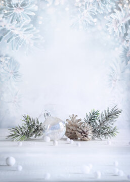Christmas still life with snowy pine cones, baubles and  fir branches on light background. Winter or Christmas festive concept.