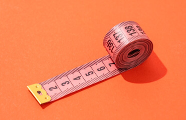 colorful measuring tapes top view on bright red background