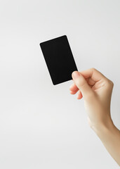 female hand holds a black plastic card on a grey background