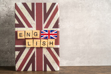 Word English on book with United Kingdom flag, learning English language courses concept.