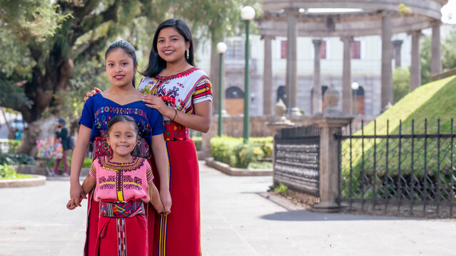 Two beautiful sisters pose in their community park to take a photo.