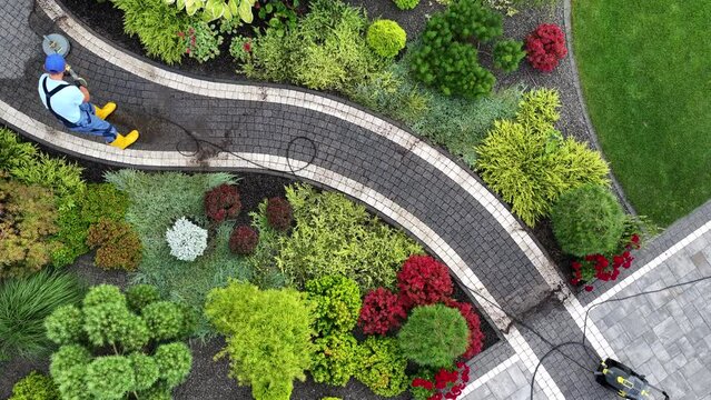 Man Pressure Washing Garden Path Using Modern Pressure Washer