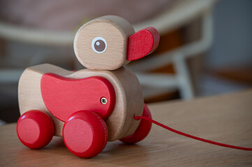 Wooden toy duck a kids toy to pull around against a blurred background