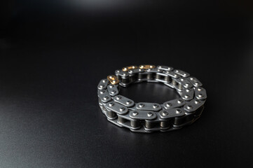 New timing chain of an internal combustion engine on a black background in selective focus. Spare parts new
