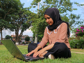 Portrait of Arab business Women working on laptop sitting at city park.