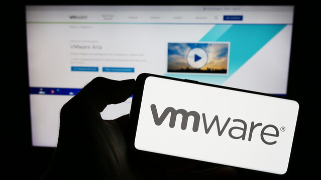 Stuttgart, Germany - 09-14-2023: Person holding smartphone with logo of US cloud computing company VMware Inc. on screen in front of website. Focus on phone display.