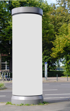 Empty advertising pillar in a city with white  free copy space, promotion mock up. Blank advertising panel