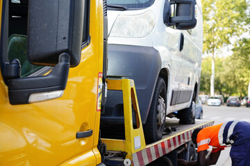 road assistance of a vehicle. A tow truck takes away a van with a flat tire. Car insurance service...