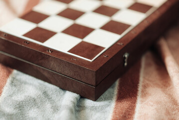 chess game, chessboard lies on fabric in brown and blue shades, blur