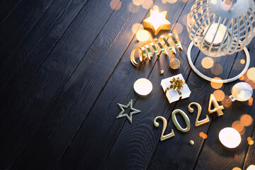 Burning lantern with Christmas decoration on black wooden table with copy space.