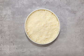 Top view of a bowl with grated Mexican Cotija cheese for food garnishing.