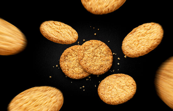Flying oatmeal cookies on black background, top view - Powered by Adobe