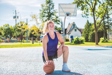 Young woman playing basketball at park basketball court