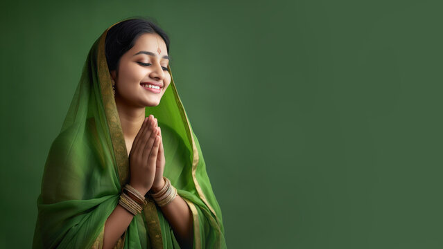 Indian Woman in green sari cloth praying, greeting diwali celebration