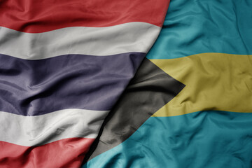 big waving national colorful flag of thailand and national flag of bahamas .