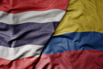big waving national colorful flag of thailand and national flag of colombia .