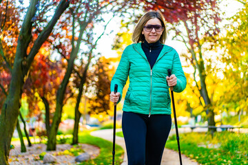 Nordic walking - woman exercising in city park

