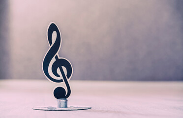Photography of treble clef standing on desk in musical class room close up