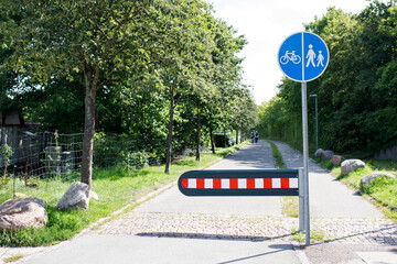 Fenced green area for cyclists and pedestrians with a blue sign on a round background, Concept of relaxation, healthy lifestyle