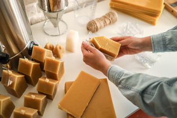 Creative activity of making candles. Woman making candles from beeswax, production