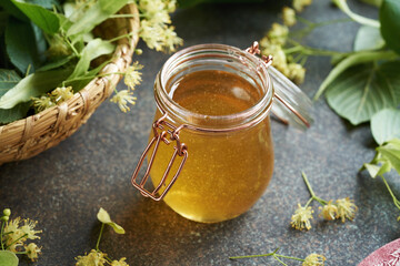 A jar of honey with fresh linden flowers