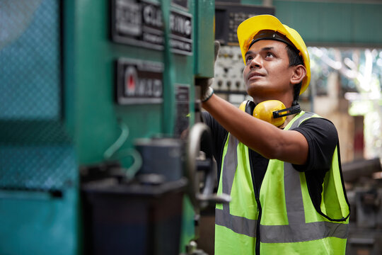 factory worker or technician checking and control lathe machine in factory
