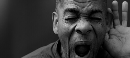 deaf man suffering from deafness and hearing loss on grey background with people stock photo	 - obrazy, fototapety, plakaty